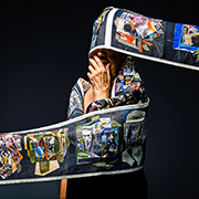 The artist wrapped in a fabric of artwork depicting scenes from October 7th